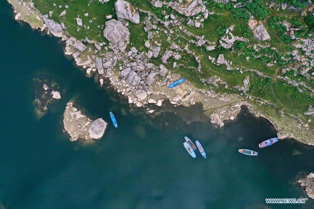 Aerial photo taken on July 24, 2021 shows ships floating near Huawu Village in Xinren Miao Township, Qianxi City, southwest China's Guizhou Province. Huawu Village, although boasting unique ethnic Miao culture and splendid mountain views with vast water bodies, once had a poverty headcount ratio as high as 63.6 percent. Taking advantage of the rich cultural and natural heritage, the local government initiated a scenic area project as a targeted measure to shake off poverty to boost tourism by constructing a 