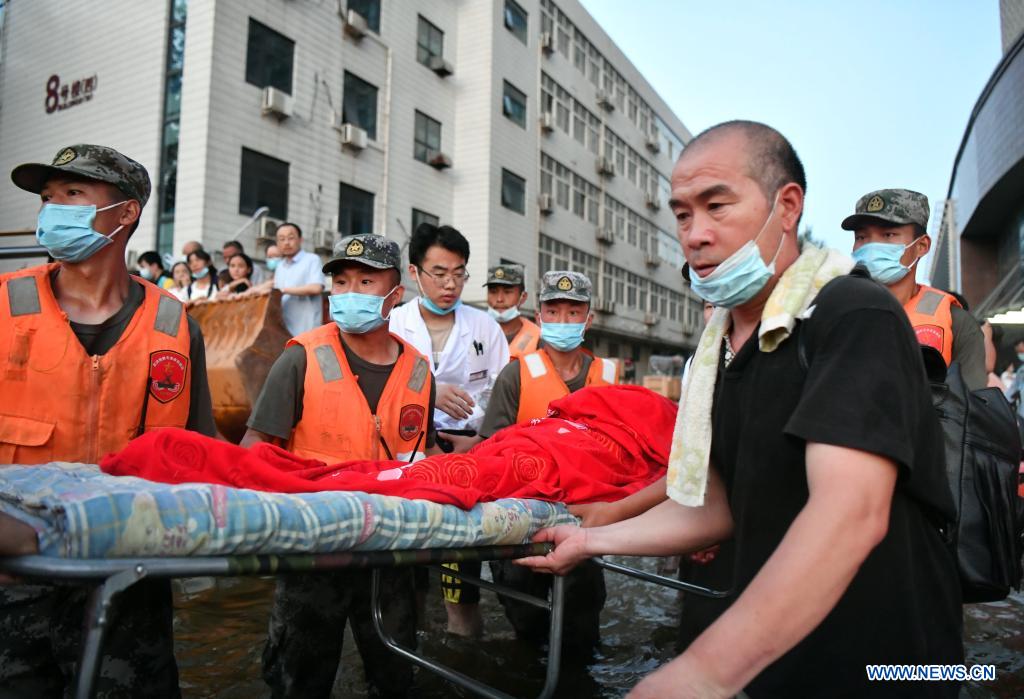 Rescuers transfer a patient to safe areas at a hospital in Weihui, Xinxiang City of central China's Henan Province, July 26, 2021. Weihui is suffering from serious flooding caused by heavy downpour in the past few days. Rescue work is still in progress there. (Xinhua/Li Jianan)