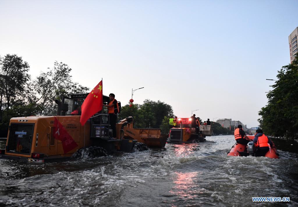 Rescuers aboard rubber boats and shovel loaders move toward a hospital in Weihui, Xinxiang City of central China's Henan Province, July 26, 2021. Weihui is suffering from serious flooding caused by heavy downpour in the past few days. Rescue work is still in progress there. (Xinhua/Li Jianan)