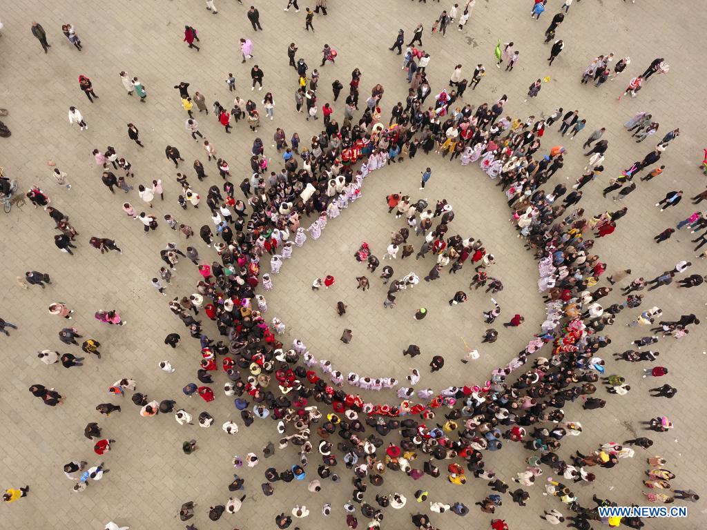 Aerial photo taken on Feb. 19, 2021 shows tourists and villagers dancing on a square at Huawu Village in Xinren Miao Township, Qianxi City, southwest China's Guizhou Province. Huawu Village, although boasting unique ethnic Miao culture and splendid mountain views with vast water bodies, once had a poverty headcount ratio as high as 63.6 percent. Taking advantage of the rich cultural and natural heritage, the local government initiated a scenic area project as a targeted measure to shake off poverty to boost tourism by constructing a 