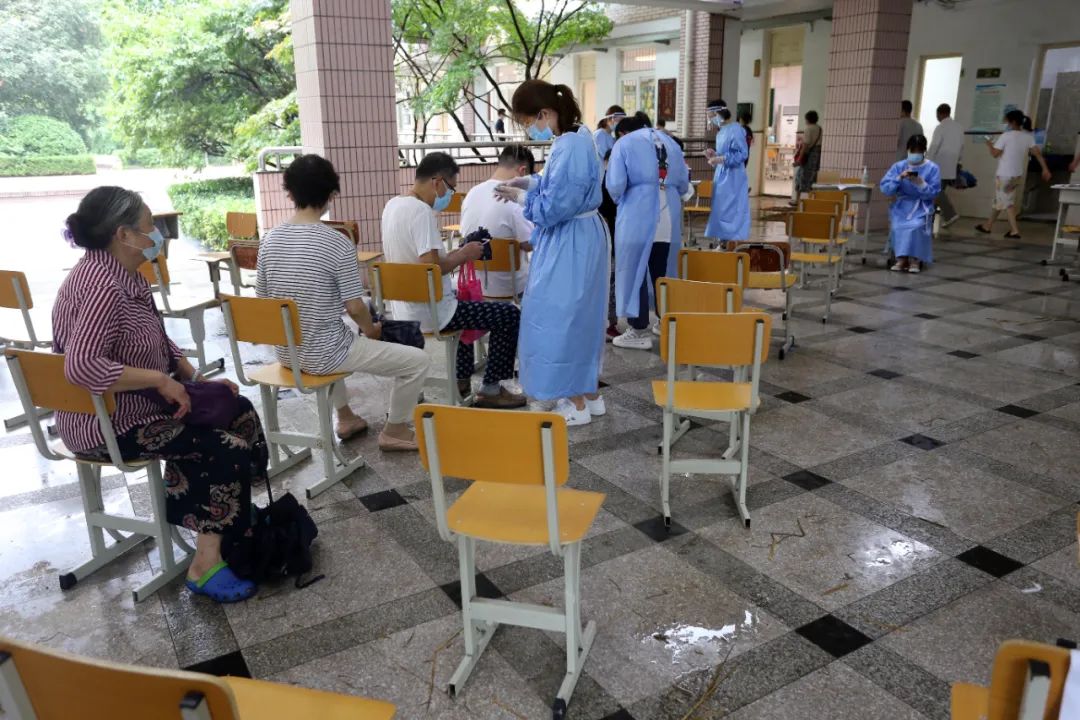 △26日，台风“烟花”持续影响南京，医务人员、志愿者等工作人员坚守岗位，确保每位市民都能顺利完成核酸检测。