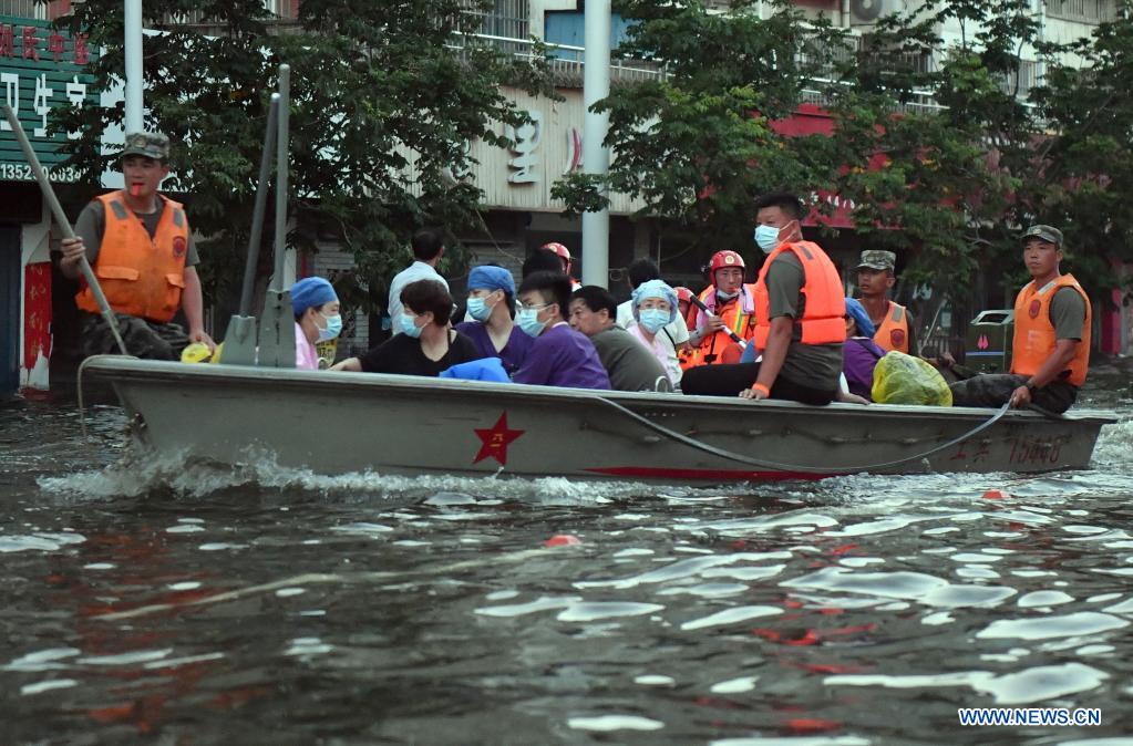 Stranded residents are transferred to safe areas aboard a rescue boat in Weihui, Xinxiang City of central China's Henan Province, July 26, 2021. Weihui is suffering from serious flooding caused by heavy downpour in the past few days. Rescue work is still in progress there. (Xinhua/Li Jianan)