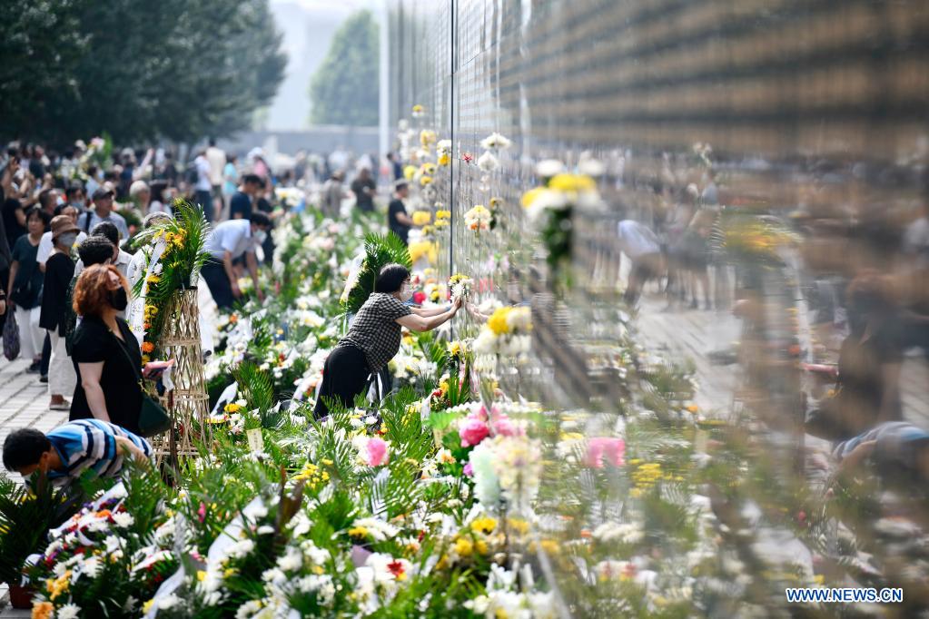 People present flowers in front of a memorial wall at the Tangshan Earthquake Memorial Park in Tangshan, north China's Hebei Province, July 28, 2021. Wednesday marks the 45th anniversary of the Tangshan earthquake. The 7.8-magnitude quake struck the city of Tangshan in Hebei Province on July 28, 1976, killing more than 240,000 people and destroying virtually all buildings. (Xinhua/Mu Yu)