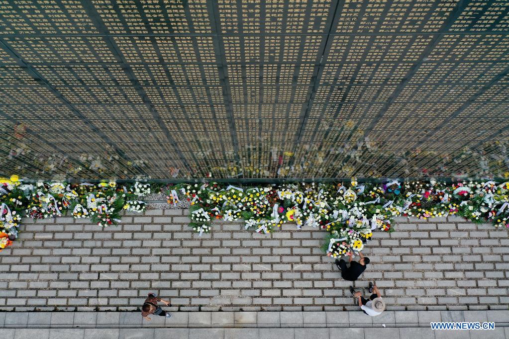 People present flowers in front of a memorial wall at the Tangshan Earthquake Memorial Park in Tangshan, north China's Hebei Province, July 28, 2021. Wednesday marks the 45th anniversary of the Tangshan earthquake. The 7.8-magnitude quake struck the city of Tangshan in Hebei Province on July 28, 1976, killing more than 240,000 people and destroying virtually all buildings. (Xinhua/Mu Yu)