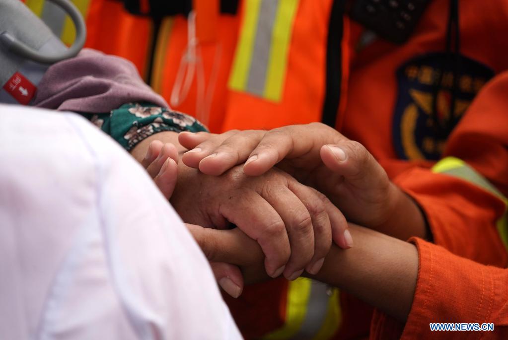 An elderly holds the hands of a rescuer after being transfered to a safe area in flood-hit Weihui City, central China's Henan Province, July 28, 2021. Weihui City suffered from severe urban waterlogging due to the extremely heavy rainfall. Rescue and drainage work is still in progress there. (Xinhua/Li An)