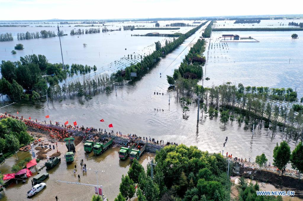 Aerial photo taken on July 29, 2021 shows rescuers and local residents reinforcing the embankment in Xunxian County, central China's Henan Province. (Xinhua/Li An)