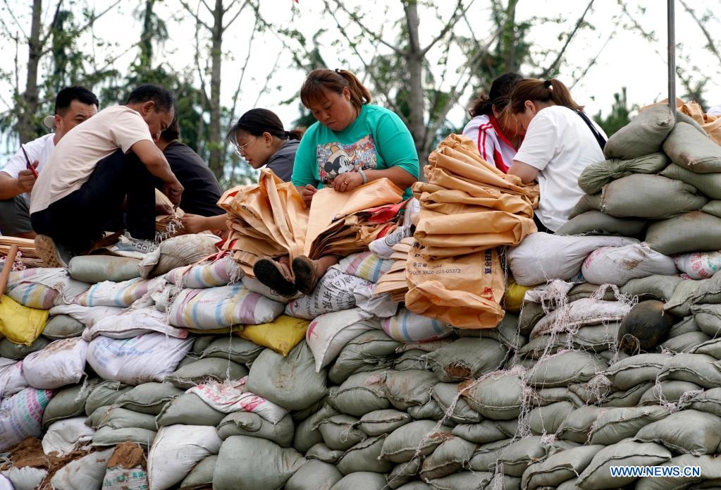 Residents make sandbags to reinforce the embankment in Xunxian County, central China's Henan Province, July 29, 2021. (Xinhua/Li An)