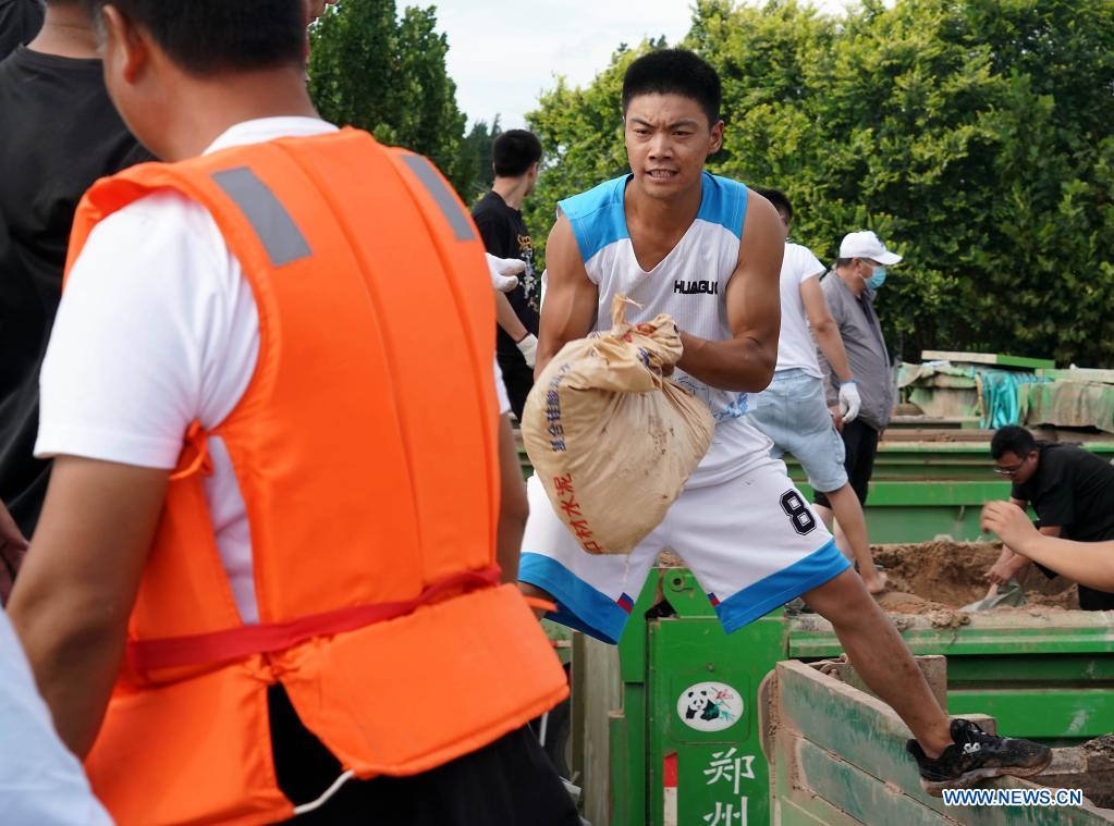 Residents carry sandbags to reinforce the embankment in Xunxian County, central China's Henan Province, July 29, 2021. (Xinhua/Li An)