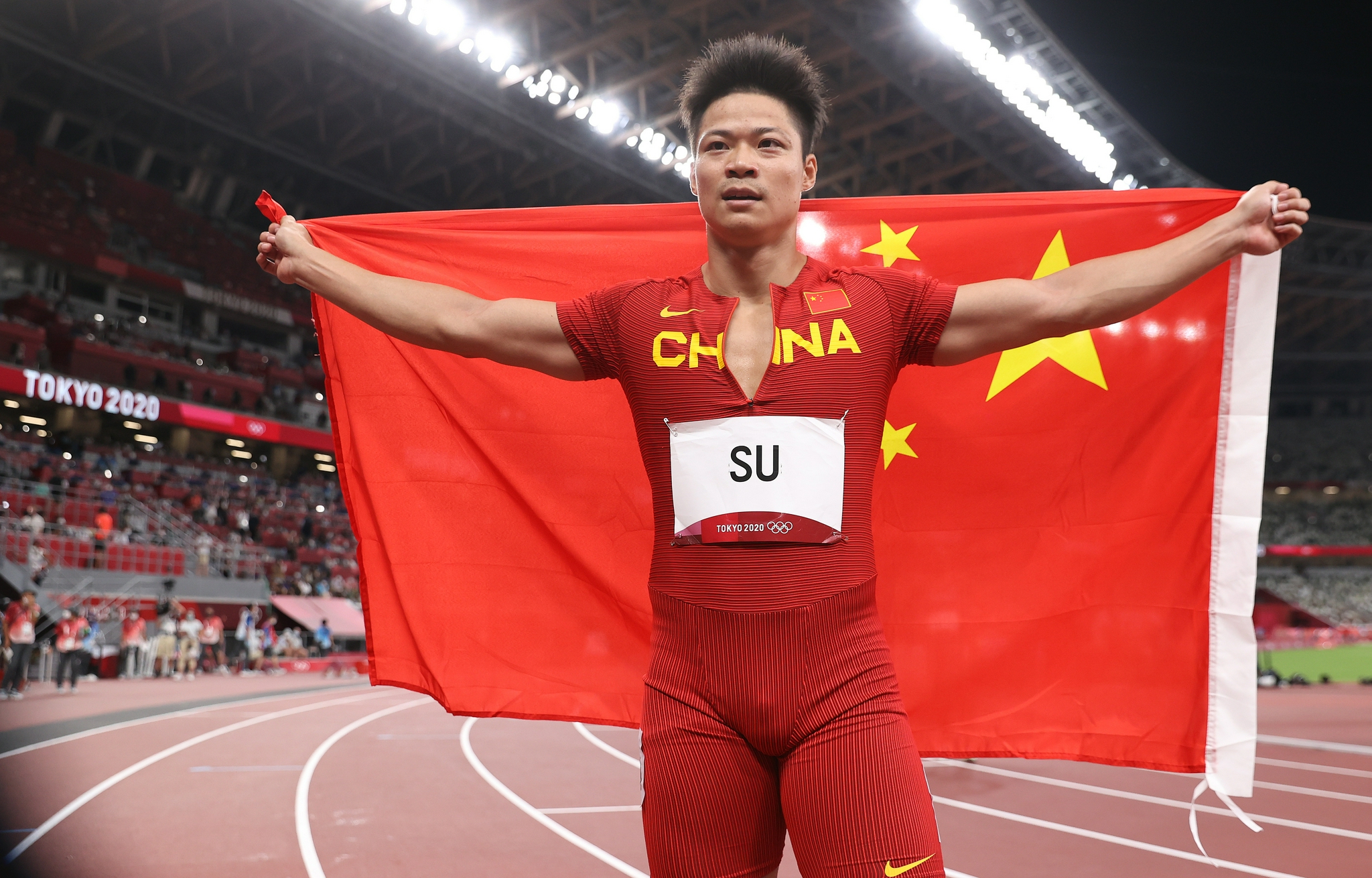 苏炳添身披国旗。