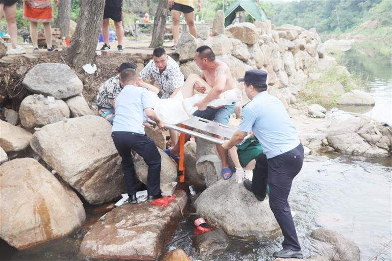 民警毕志豪和辅警队员从救护车上取下担架,与伤者家属一同将女子平稳