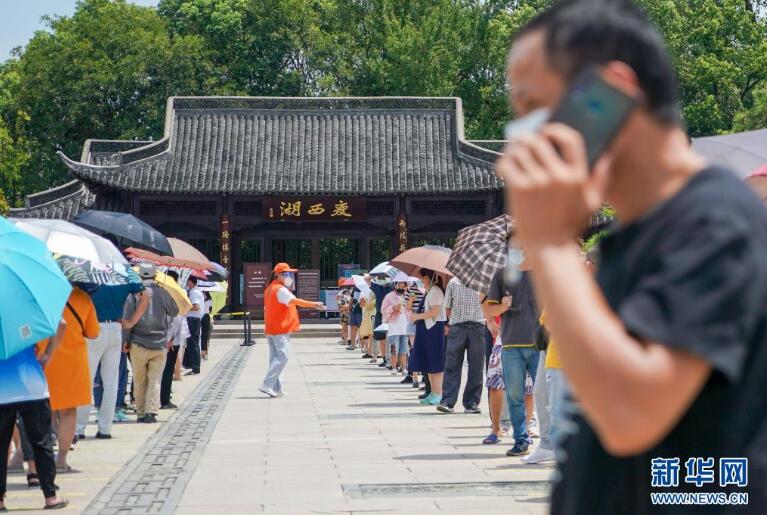 市民在扬州市瘦西湖街道五亭社区瘦西湖西门采样点排队,准备进行核酸检测(8月7日摄)。 新华社记者 李博 摄