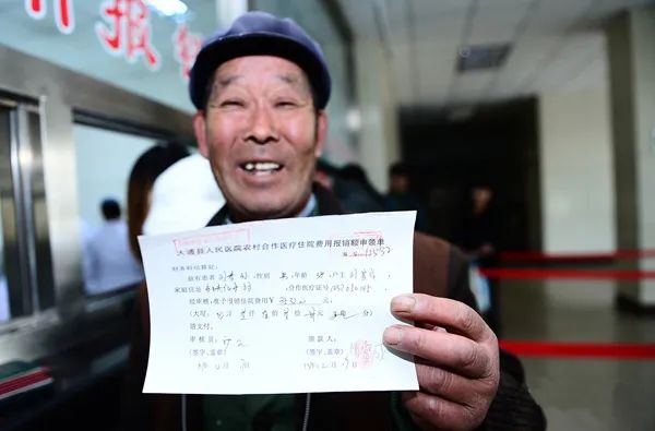 63岁的刘富成在展示儿子住院费用的报销单