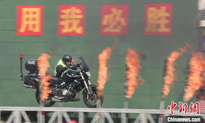 北京市公安局举办的开放日活动现场，摩托车队的特警队员依次穿过障碍火桥。 贾天勇 摄