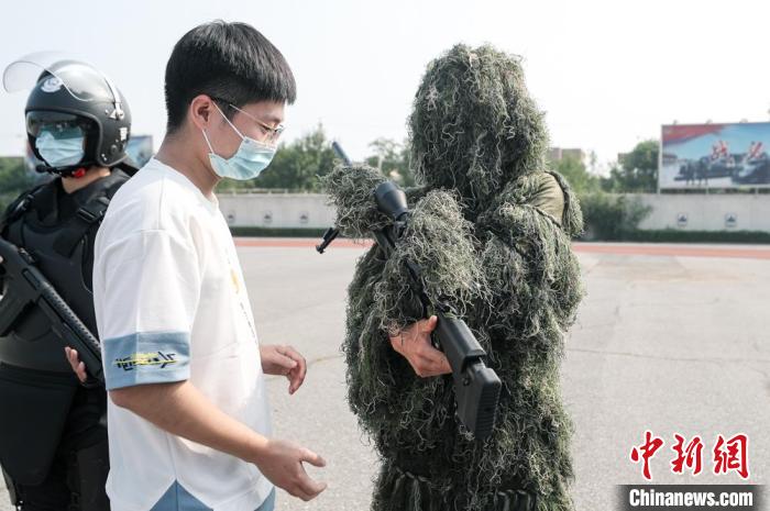 北京市公安局举办的开放日活动现场，特警狙击手向参观者介绍狙击枪的构造。 贾天勇 摄