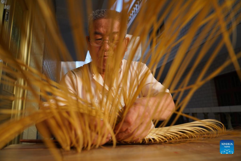 Li Nian'gen makes bamboo-weaving products in Dongcun Township, Fenyi County, Xinyu City of east China's Jiangxi Province, Sept. 1, 2021. Li Nian'gen, 62, is the fifth-generation inheritor of bamboo-weaving techniques in Dongcun Township. Li acquired bamboo-weaving techniques from his uncle when he was barely nine years old, and started to make a living on his own at the age of 15. More than 20 of his apprentices chose to seek employment for better income in other walks of life away from home in early 1990s, but Li decided to stay and stick to his profession. Li occasionally demonstrated his bamboo-weaving techniques on a video clip platform as suggested by others in 2019, and became increasingly popular ever since then. Now Li has more than 8 million followers on different platforms, with his short videos popular among netizens. (Xinhua/Zhou Mi)