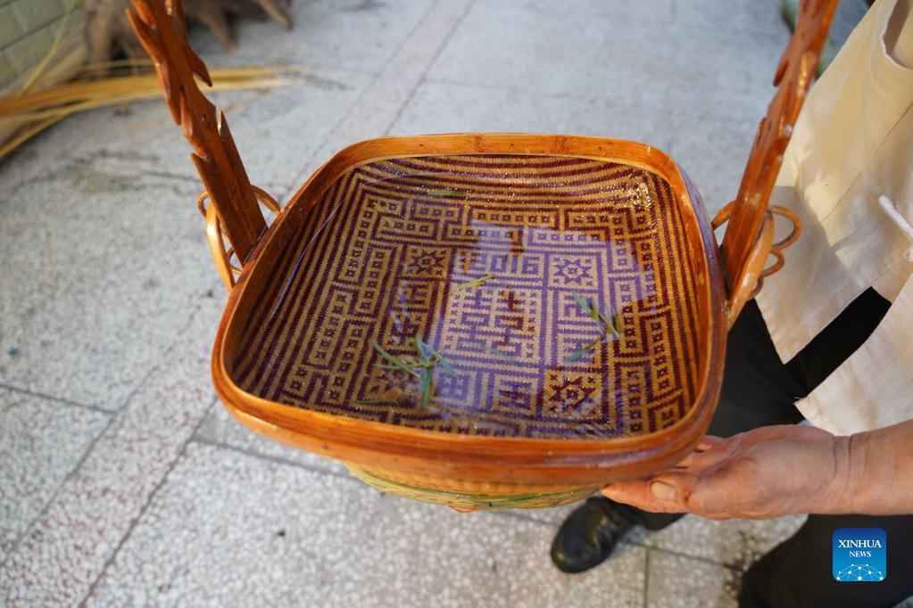 Li Nian'gen shows a bamboo basket, one of his bamboo-weaving products, in Dongcun Township, Fenyi County, Xinyu City of east China's Jiangxi Province, Sept. 1, 2021. Li Nian'gen, 62, is the fifth-generation inheritor of bamboo-weaving techniques in Dongcun Township. Li acquired bamboo-weaving techniques from his uncle when he was barely nine years old, and started to make a living on his own at the age of 15. More than 20 of his apprentices chose to seek employment for better income in other walks of life away from home in early 1990s, but Li decided to stay and stick to his profession. Li occasionally demonstrated his bamboo-weaving techniques on a video clip platform as suggested by others in 2019, and became increasingly popular ever since then. Now Li has more than 8 million followers on different platforms, with his short videos popular among netizens. (Xinhua/Zhou Mi)