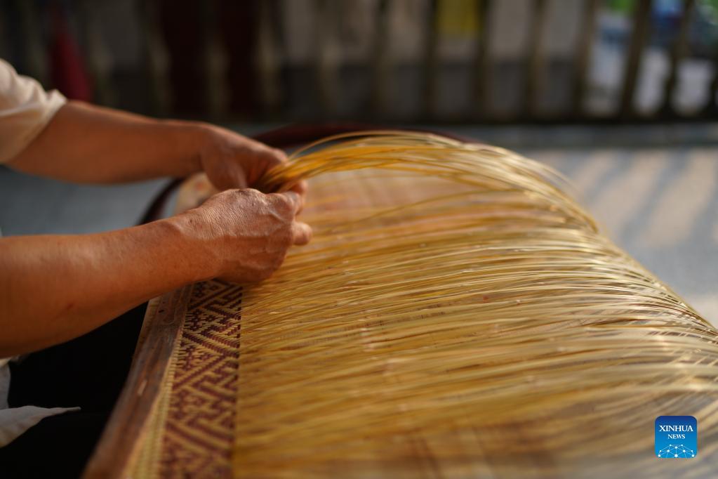 Li Nian'gen makes bamboo-weaving products in Dongcun Township, Fenyi County, Xinyu City of east China's Jiangxi Province, Sept. 1, 2021. Li Nian'gen, 62, is the fifth-generation inheritor of bamboo-weaving techniques in Dongcun Township. Li acquired bamboo-weaving techniques from his uncle when he was barely nine years old, and started to make a living on his own at the age of 15. More than 20 of his apprentices chose to seek employment for better income in other walks of life away from home in early 1990s, but Li decided to stay and stick to his profession. Li occasionally demonstrated his bamboo-weaving techniques on a video clip platform as suggested by others in 2019, and became increasingly popular ever since then. Now Li has more than 8 million followers on different platforms, with his short videos popular among netizens. (Xinhua/Zhou Mi)