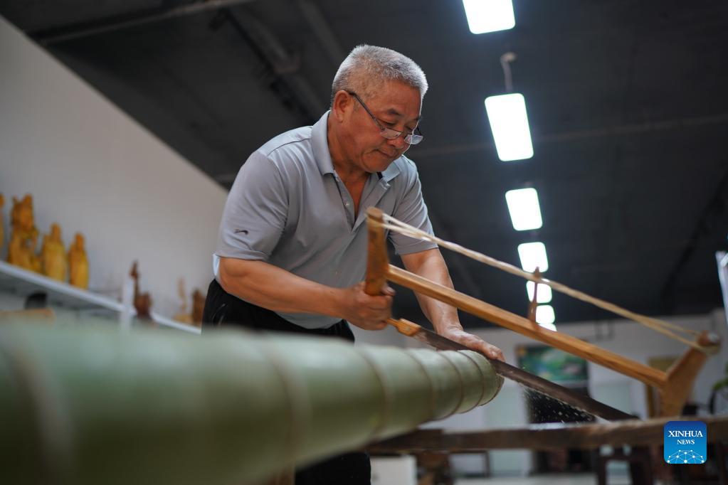 Li Nian'gen prepares raw material for his bamboo products in Dongcun Township, Fenyi County, Xinyu City of east China's Jiangxi Province, Sept. 2, 2021. Li Nian'gen, 62, is the fifth-generation inheritor of bamboo-weaving techniques in Dongcun Township. Li acquired bamboo-weaving techniques from his uncle when he was barely nine years old, and started to make a living on his own at the age of 15. More than 20 of his apprentices chose to seek employment for better income in other walks of life away from home in early 1990s, but Li decided to stay and stick to his profession. Li occasionally demonstrated his bamboo-weaving techniques on a video clip platform as suggested by others in 2019, and became increasingly popular ever since then. Now Li has more than 8 million followers on different platforms, with his short videos popular among netizens. (Xinhua/Zhou Mi)