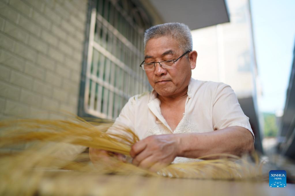 Li Nian'gen makes bamboo-weaving products in Dongcun Township, Fenyi County, Xinyu City of east China's Jiangxi Province, Sept. 1, 2021. Li Nian'gen, 62, is the fifth-generation inheritor of bamboo-weaving techniques in Dongcun Township. Li acquired bamboo-weaving techniques from his uncle when he was barely nine years old, and started to make a living on his own at the age of 15. More than 20 of his apprentices chose to seek employment for better income in other walks of life away from home in early 1990s, but Li decided to stay and stick to his profession. Li occasionally demonstrated his bamboo-weaving techniques on a video clip platform as suggested by others in 2019, and became increasingly popular ever since then. Now Li has more than 8 million followers on different platforms, with his short videos popular among netizens. (Xinhua/Zhou Mi)