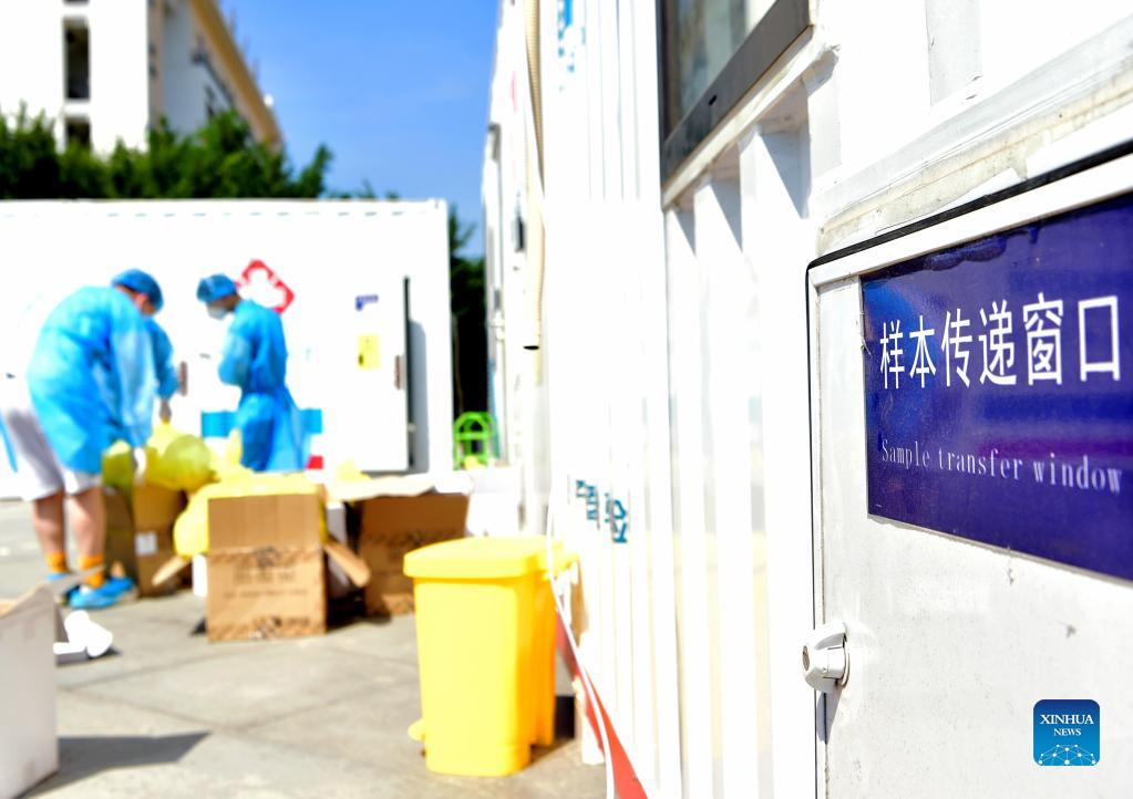 Staff members dispose medical waste outside a PCR (polymerase chain reaction) lab for nucleic acid testing in Xianyou County, southeast China's Fujian Province, Sept. 14, 2021. Three PCR labs have been built in the county to boost nucleic acid detection capacity. (Xinhua/Wei Peiquan)