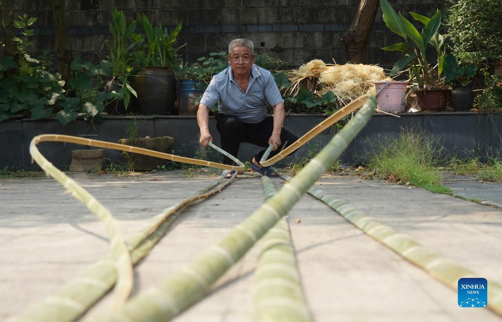 Li Nian'gen prepares raw material for his bamboo products in Dongcun Township, Fenyi County, Xinyu City of east China's Jiangxi Province, Sept. 2, 2021. Li Nian'gen, 62, is the fifth-generation inheritor of bamboo-weaving techniques in Dongcun Township. Li acquired bamboo-weaving techniques from his uncle when he was barely nine years old, and started to make a living on his own at the age of 15. More than 20 of his apprentices chose to seek employment for better income in other walks of life away from home in early 1990s, but Li decided to stay and stick to his profession. Li occasionally demonstrated his bamboo-weaving techniques on a video clip platform as suggested by others in 2019, and became increasingly popular ever since then. Now Li has more than 8 million followers on different platforms, with his short videos popular among netizens. (Xinhua/Zhou Mi)