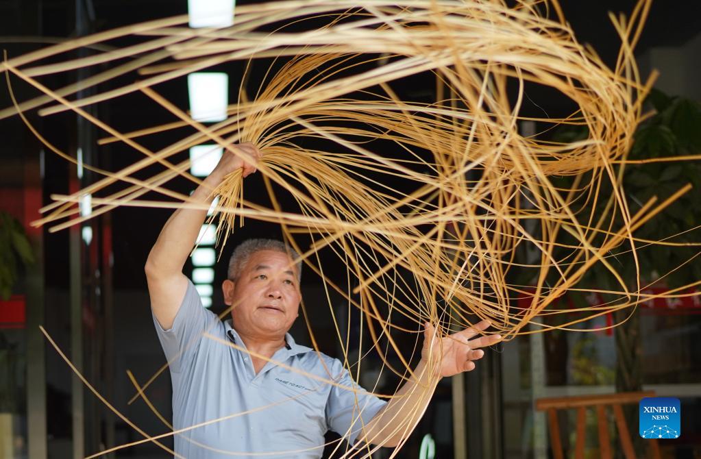 Li Nian'gen makes bamboo-weaving products in Dongcun Township, Fenyi County, Xinyu City of east China's Jiangxi Province, Sept. 2, 2021. Li Nian'gen, 62, is the fifth-generation inheritor of bamboo-weaving techniques in Dongcun Township. Li acquired bamboo-weaving techniques from his uncle when he was barely nine years old, and started to make a living on his own at the age of 15. More than 20 of his apprentices chose to seek employment for better income in other walks of life away from home in early 1990s, but Li decided to stay and stick to his profession. Li occasionally demonstrated his bamboo-weaving techniques on a video clip platform as suggested by others in 2019, and became increasingly popular ever since then. Now Li has more than 8 million followers on different platforms, with his short videos popular among netizens. (Xinhua/Zhou Mi)