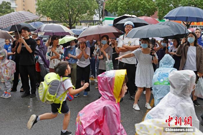 资料图:家长在校外接孩子放学回家。殷立勤 摄