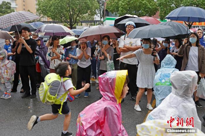 资料图：家长在校外接孩子放学回家。殷立勤 摄