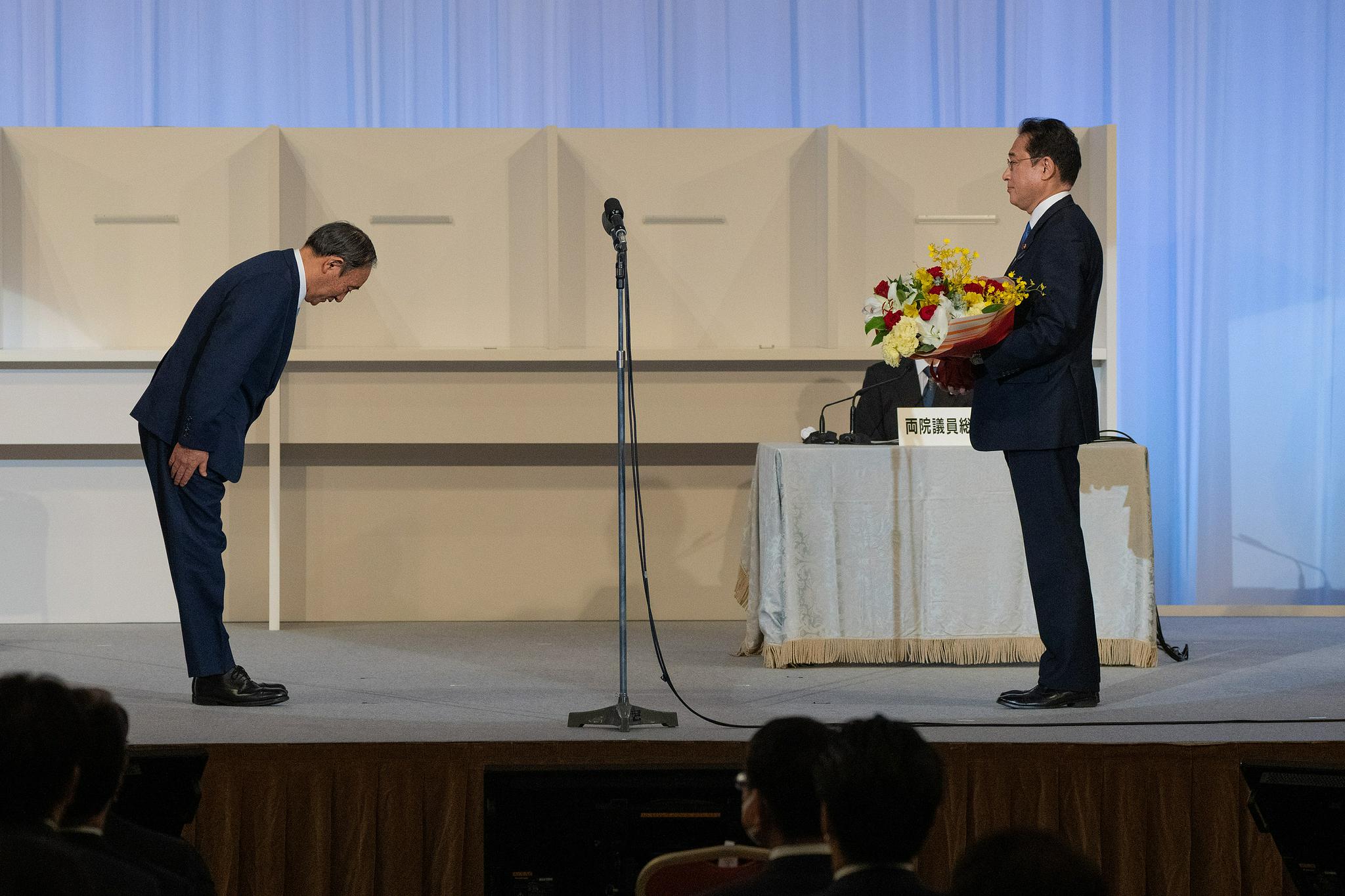 即将卸任的首相菅义伟向岸田鞠躬表示祝贺 图自视觉中国