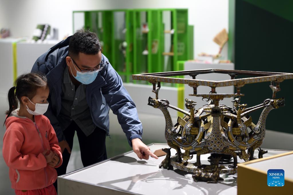 People watch cultural and creative products displayed at the Shijiazhuang Library in Shijiazhuang, capital of north China's Hebei Province, Oct. 6, 2021. The library hosted a series of cultural events to better entertain visitors during the week-long National Day holiday starting from Oct. 1. (Xinhua/Luo Xuefeng)