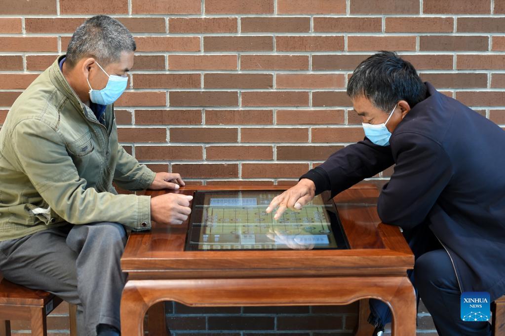 Poeple play Chinese chess on an electronic device at the Shijiazhuang Library in Shijiazhuang, capital of north China's Hebei Province, Oct. 6, 2021. The library hosted a series of cultural events to better entertain visitors during the week-long National Day holiday starting from Oct. 1. (Xinhua/Luo Xuefeng)