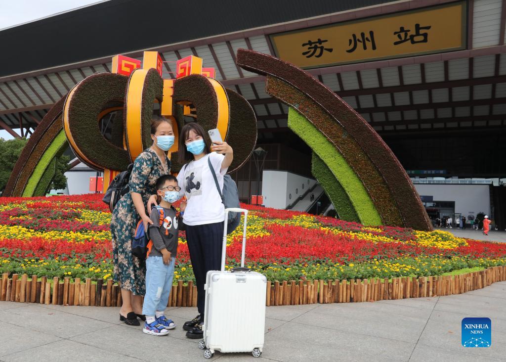(211007) -- SUZHOU, Oct. 7, 2021 (Xinhua) -- Passengers take selfies before their return trip at the Suzhou railway station in Suzhou, east China's Jiangsu Province, Oct. 7, 2021. Transportation hubs across China are witnessing the peak of return passengers as the week-long holiday draws to an end on Thursday. (Photo by Hang Xingwei/Xinhua)