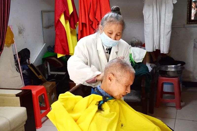 唐金莲为小区居民理发。图片来源:长沙文明网 通讯员 陈丹妮