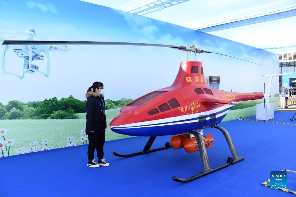 A visitor looks at a pilotless helicopter at an exhibition to mark the 2021 National Mass Innovation and Entrepreneurship Week in Beijing, capital of China, Oct. 19, 2021. The 2021 National Mass Innovation and Entrepreneurship Week was opened on Tuesday. (Xinhua/Ren Chao)