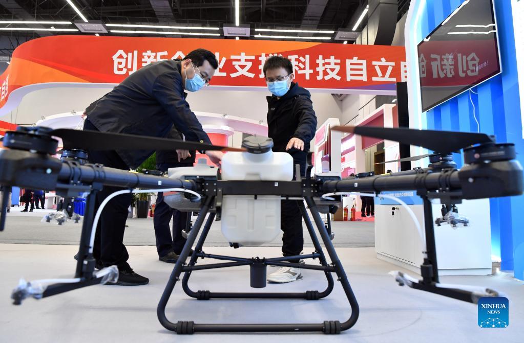 A staff member introduces a drone for agricultural purpose at the leading event to mark the 2021 National Mass Innovation and Entrepreneurship Week in Zhengzhou, capital of central China's Henan Province, Oct. 19, 2021. The 2021 National Mass Innovation and Entrepreneurship Week kicked off across the country on Tuesday. (Xinhua/Li Jianan)