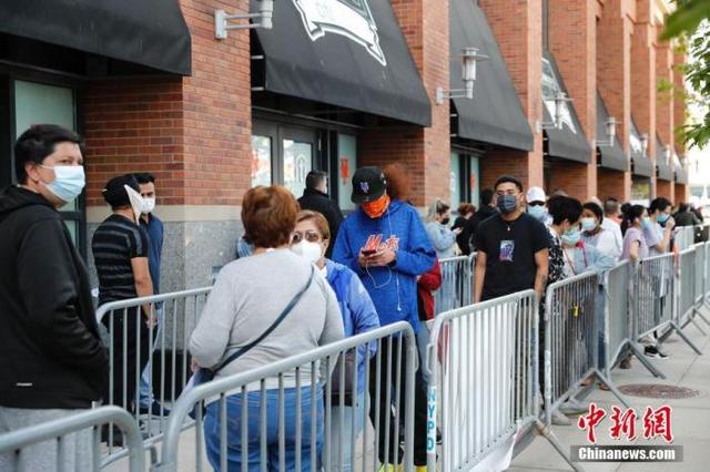资料图:当地时间5月12日,美国纽约大都会棒球队主场花旗球场新冠疫苗接种点,民众排队接种疫苗。 中新社记者 廖攀 摄