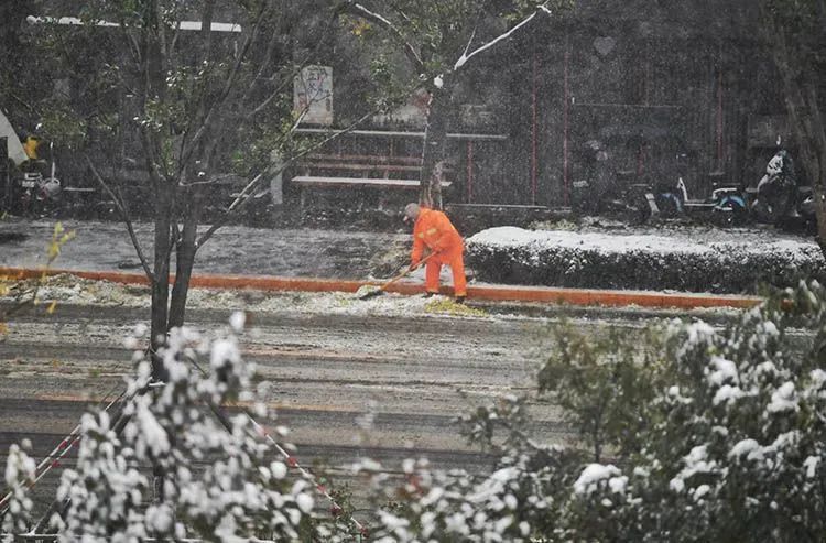 ▲东四十条，环卫工人正在清除道路中的积雪。