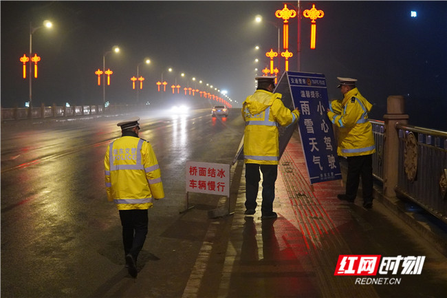 颜莫羿和同事雨雪天气夜巡，查看各个易结冰的桥面和重点路段，摆放温馨提示牌。