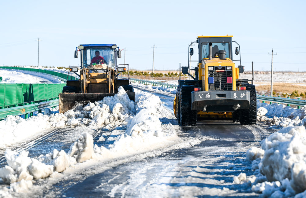 ↑11月10日，在内蒙古赤峰市303国道上，作业车辆清理积雪。