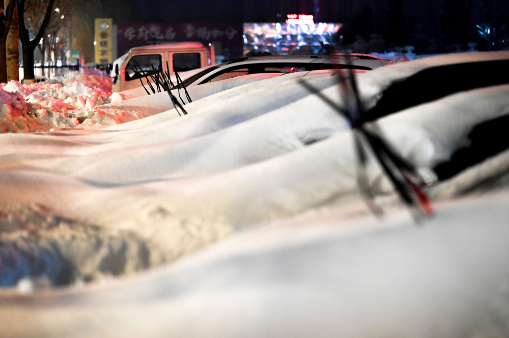  ↑11月10日，在内蒙古通辽市，汽车被积雪覆盖。