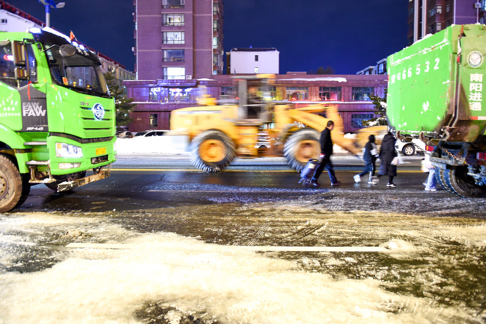  ↑11月10日，在内蒙古通辽市，作业车辆在路上清理积雪。