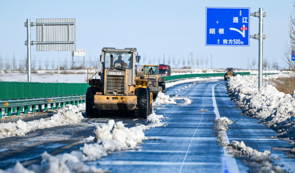  ↑11月10日，在内蒙古赤峰市303国道上，作业车辆清理积雪。