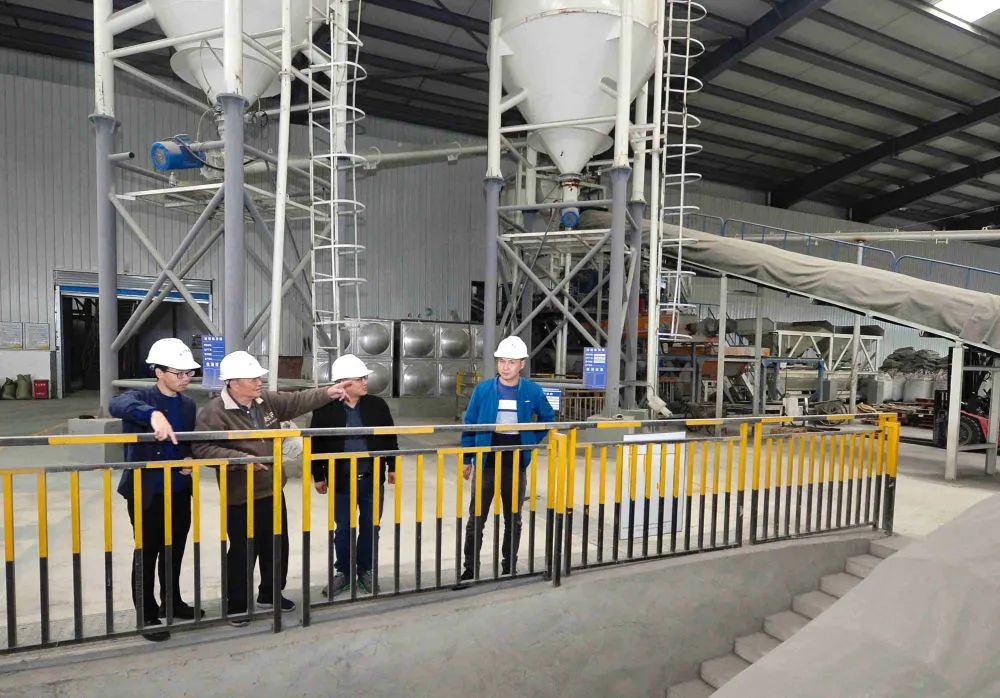 ▲11月4日，王其昌（左二）在声屏障吸声板生产厂查看生产线