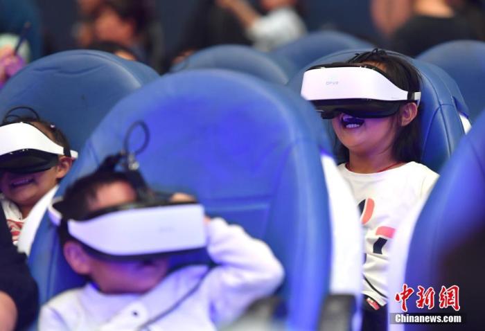 儿童戴着VR眼镜体验“太空飞行”。中新社记者 任东 摄