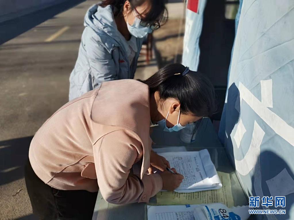 赞皇县北潘村红白理事会成员在村口疫情防控点值守，让返程人员登记、扫码、测温。11月11日拍摄。受访者提供