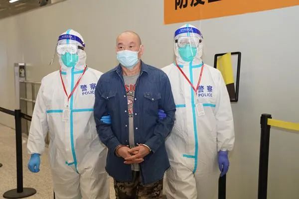 许国俊(中)被强制遣返回国 图源:中央纪委国家监委网站