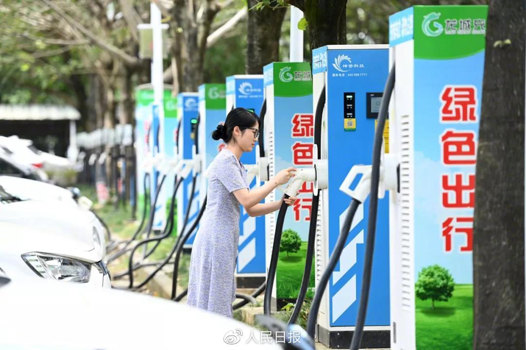 广西柳州市市民在充电站给新能源汽车充电。（黎寒池/人民视觉）