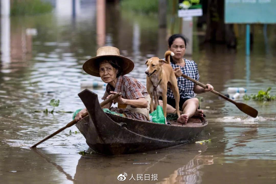 世界气象组织10月发布最新报告说，由于气候变化，全球洪水和干旱等与水有关的危害正在增加。图为人们划船通过泰国大城府被洪水淹没区域。（新华社/法新）