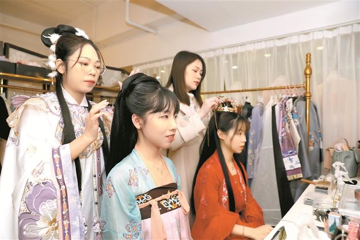 ▲钟美华(后排右)和同事在为顾客设计妆容。深圳晚报记者 张焱焱 摄