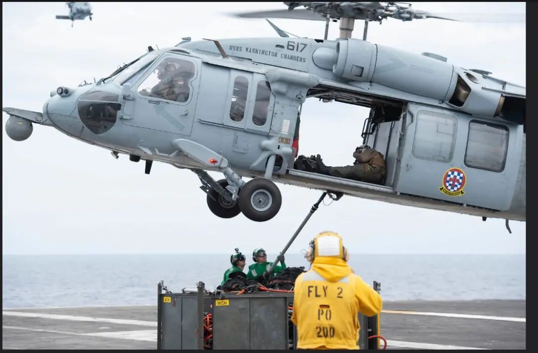 图为“卡尔·文森”号航母所属的舰载直升机27日在菲律宾海进行物资转运的画面。